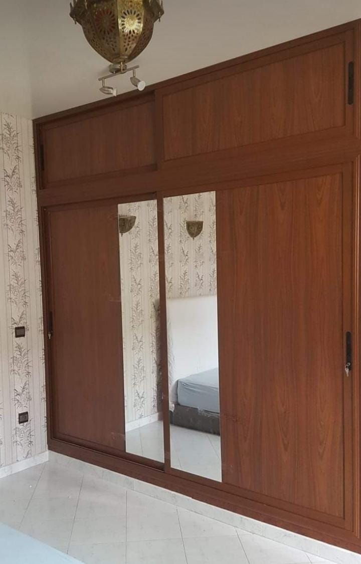 Placard encastré en bois avec portes coulissantes et miroir intégré — réalisé par Jouissance