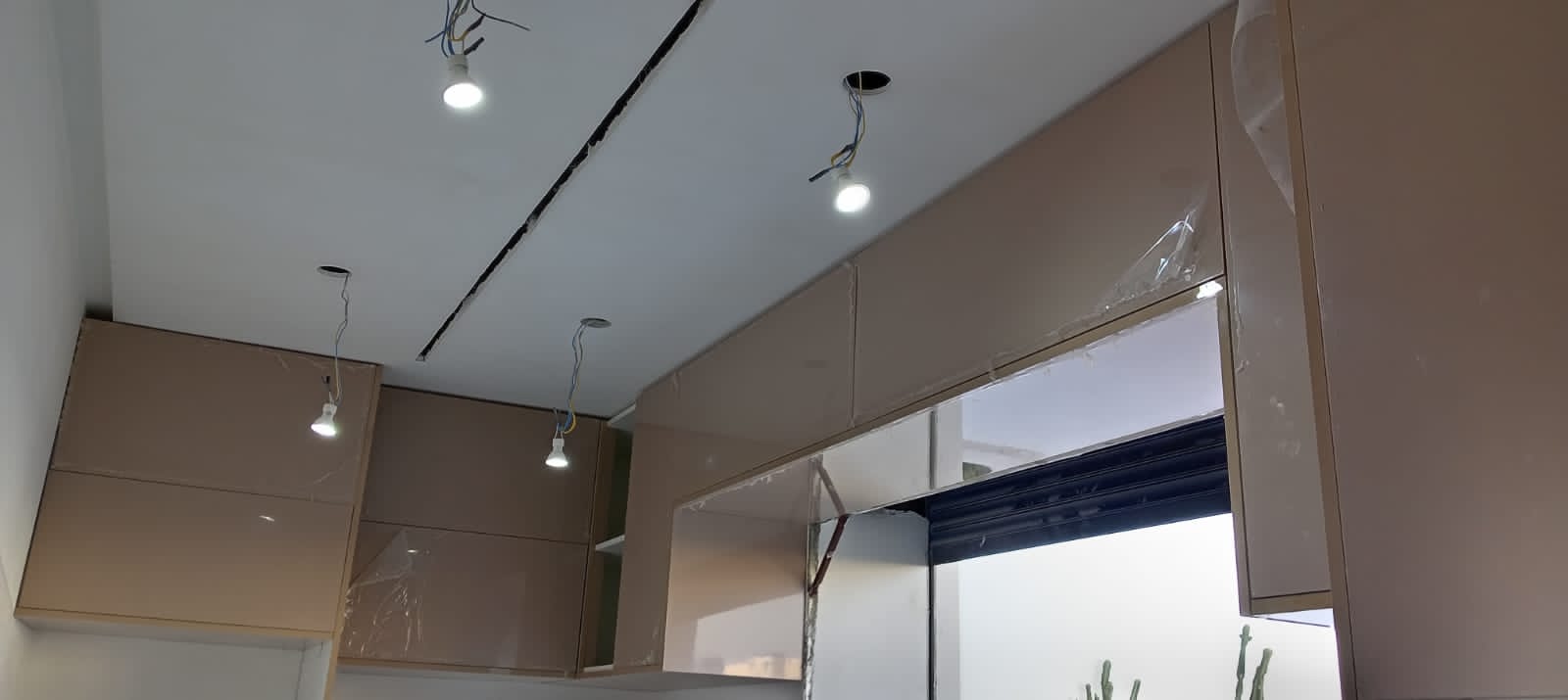 Meubles hauts de cuisine en cours d'installation avec spots LED — chantier Jouissance