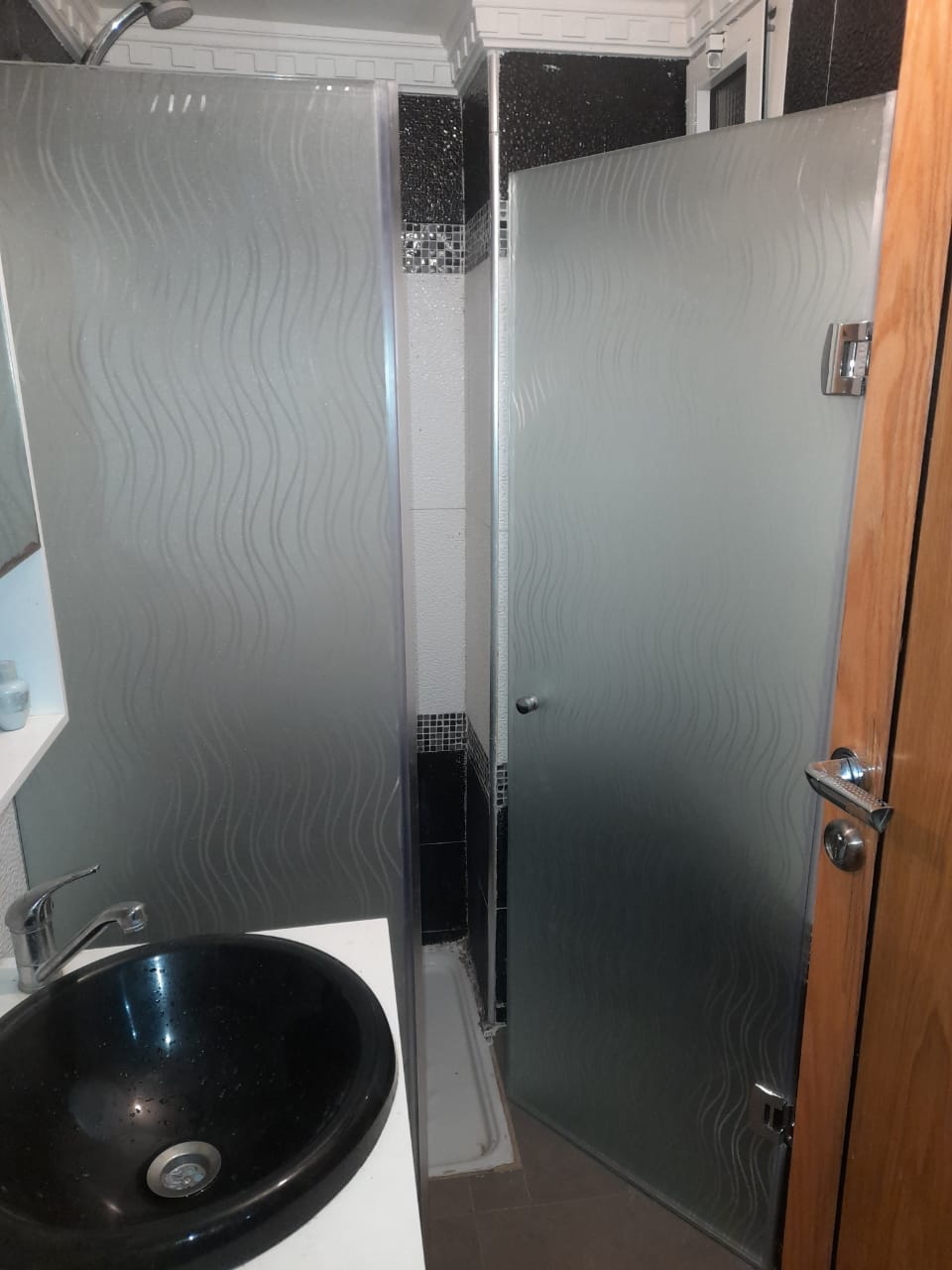 Salle de bain avec paroi de douche en verre dépoli et vasque noire — réalisée par Jouissance